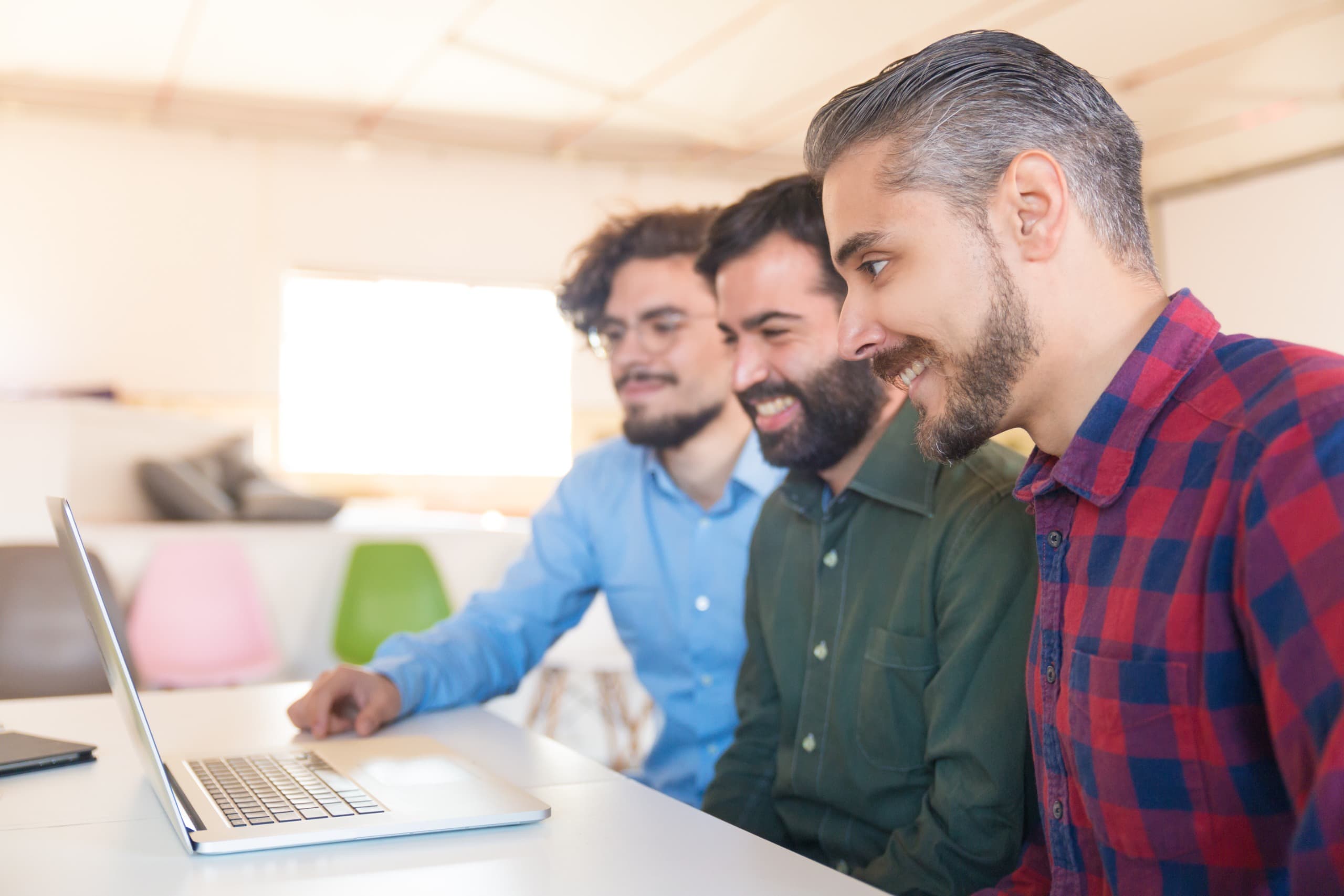 A team collaborating around a laptop in the office